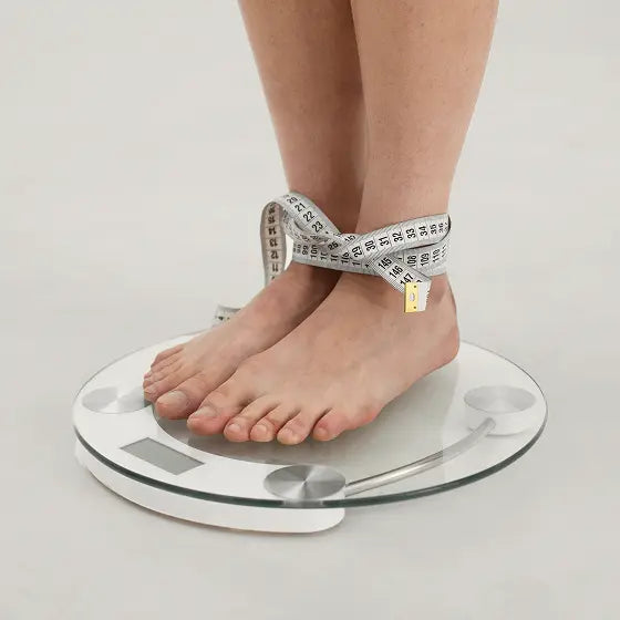 Feet on a scale with a measuring tape
