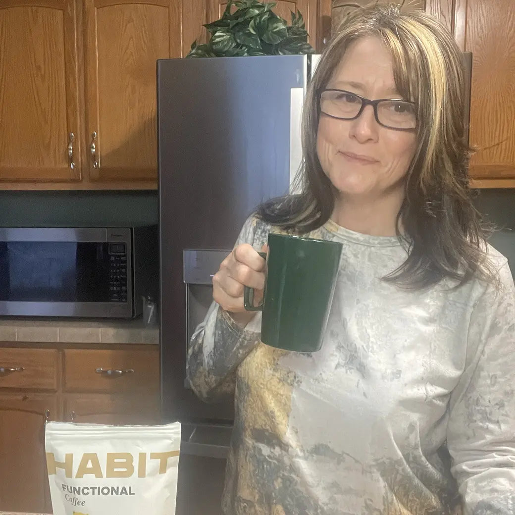 Woman holding a mug, HabitONE pack beside her